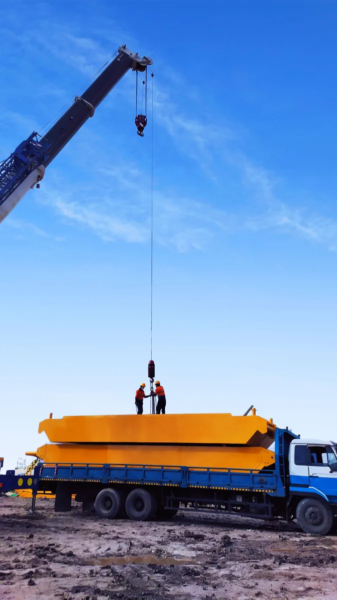 Crane handling heavy equipment at an industrial worksite